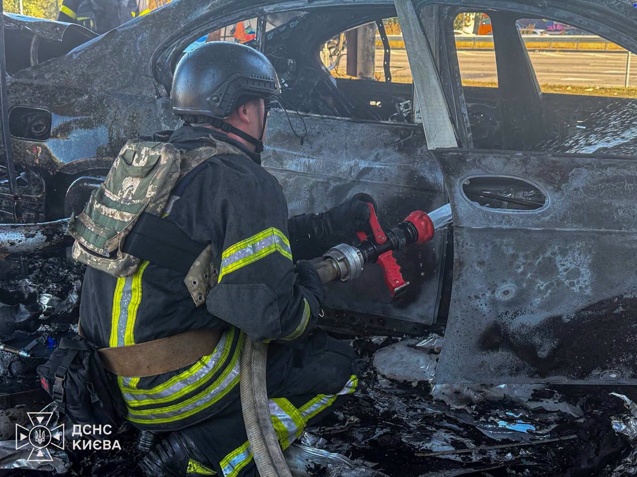 Рятувальник гасить пожежу в автівці, що опинилася в епіцентрі вибуху