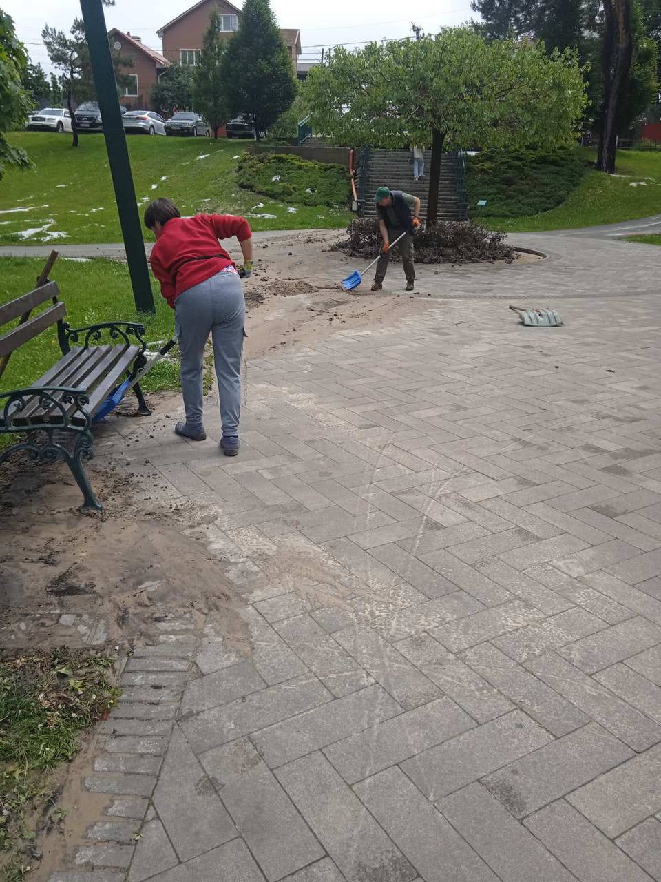 Комунальники прибирають мул на пісок, нанесені зливою на тротуари