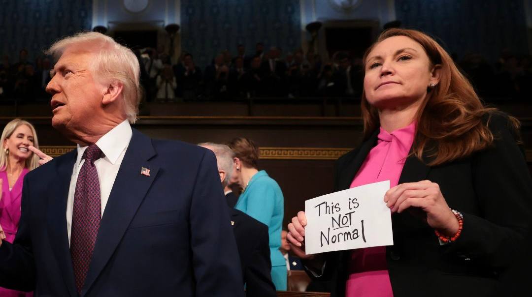 Конгресвумен з табличкою «Це не нормально» позаду Трампа