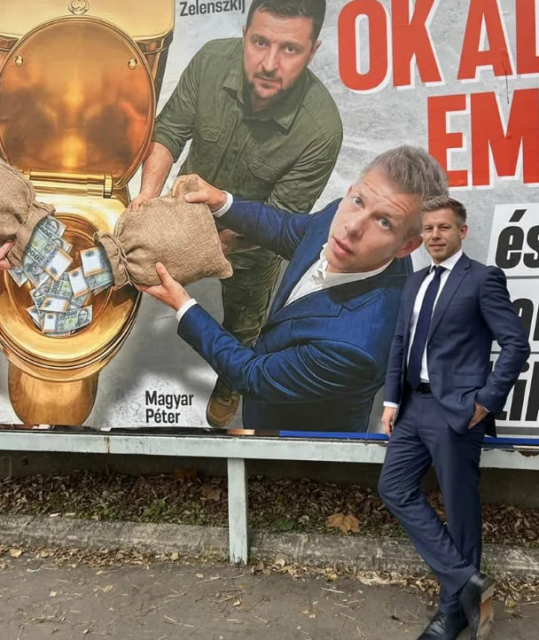 Петер Мадяр на фоні пропагандистського білборда Орбана