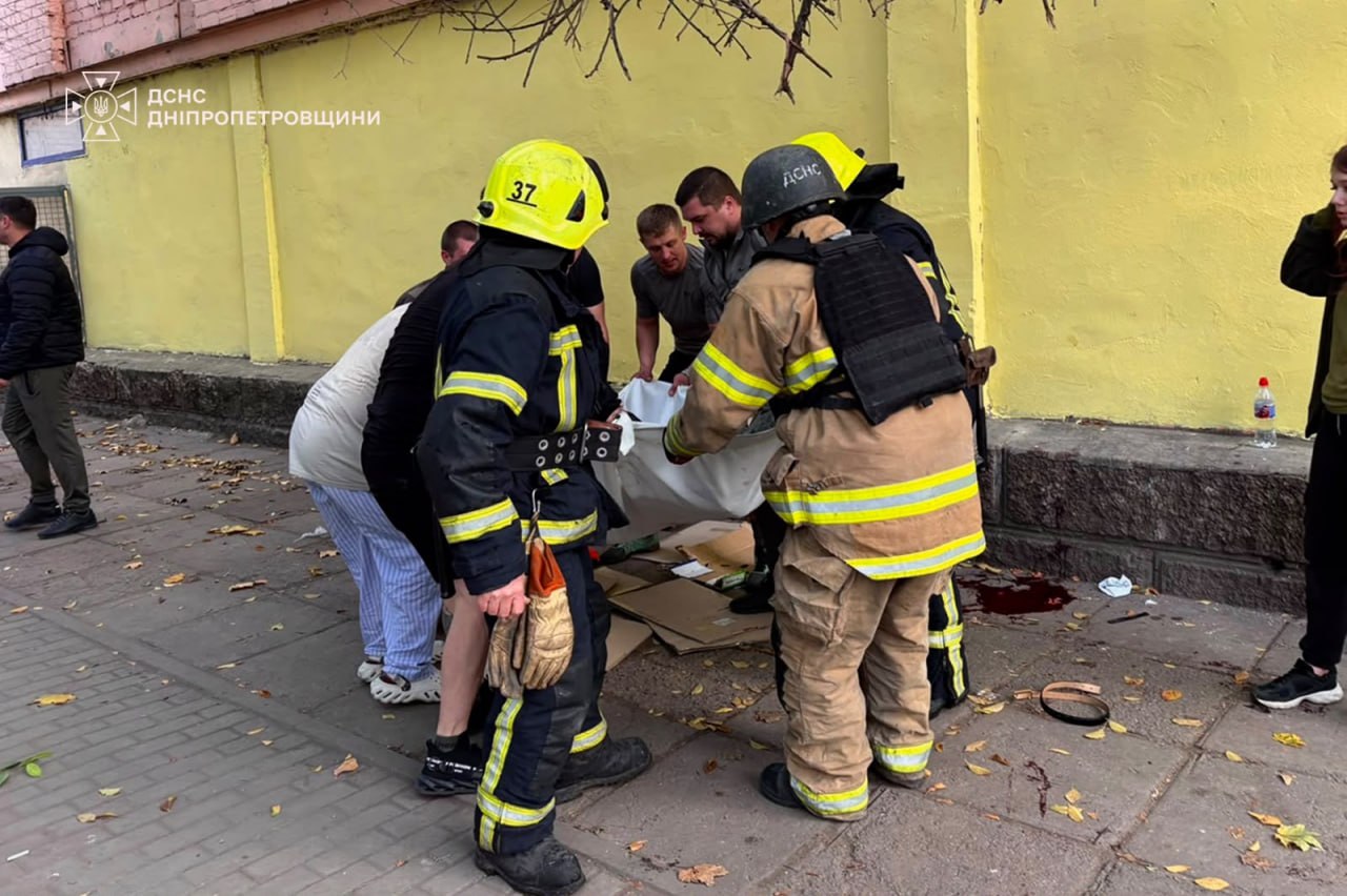 Рятувальники та місцеві жителі на місці російської атаки в Павлограді