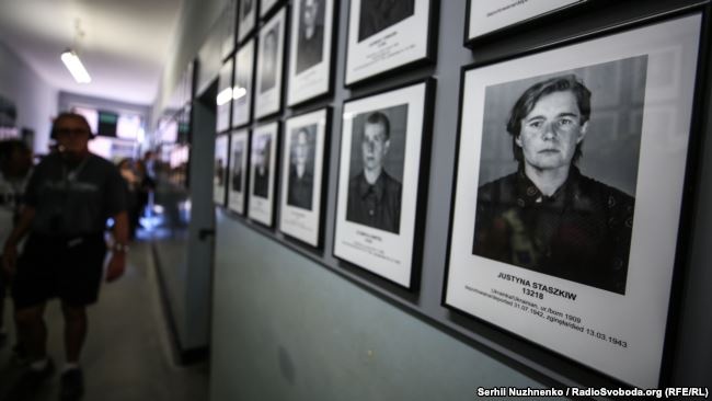 Фотографія українки (праворуч) на території колишнього нацистського концтабору Аушвіц-Біркенау біля міста Освенцима (Польща), де тепер діє музей. У концтаборі утримували понад 14,5 тисяч вихідців із території України