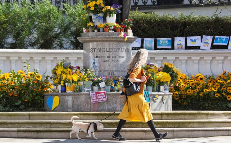 Жінка в Лондоні проходить повз статую Святого Володимира, прикрашену соняшниками на знак солідарності з українським народом (Фото: EPA)