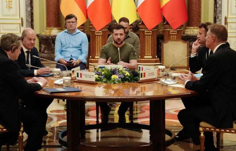 Міністр закордонних справ Дмитро Кулеба (на задньому плані) під час зустрічі лідерів був не дуже веселим
