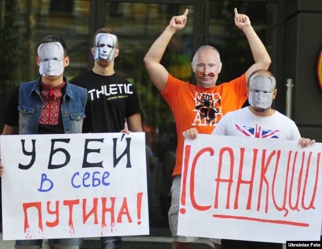 Люди в масках Путіна біля посольства Німеччини в Україні закликають посилити санкції проти Росії. Київ, 24 липня 2014 року