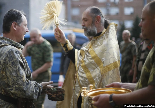 Священник Московского патриархата благословляет Игоря Гиркина, который на то время был одним из главарей группировки «ДНР», признанной в Украине терористической. Оккупированный Донецк, 10 июля 2014 года