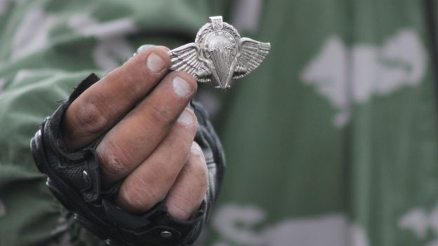 Боевик «ЛНР» держит знак украинских десантников на месте падения Ил-76