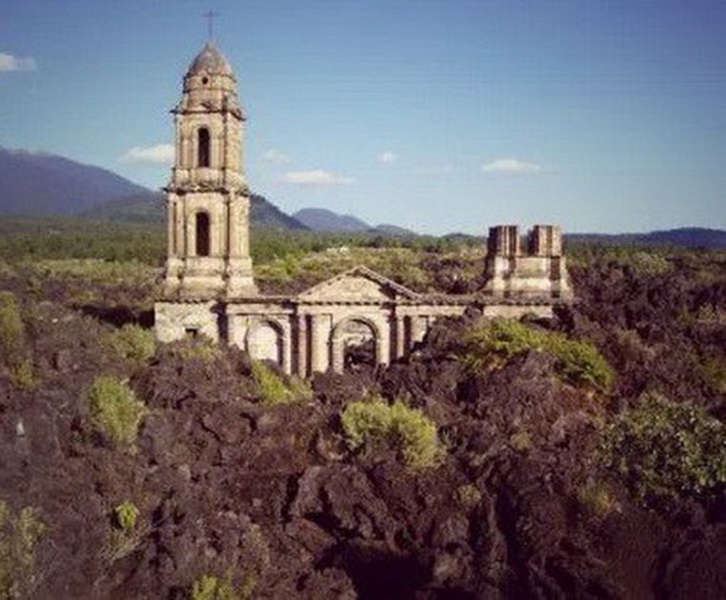 Церковь Сан Хуан Парангарикутиро (San Juan Parangaricutiro), Мичоакан. В Мексике существуют тысячи удивительных церквей, которые стоит увидеть, но наполовину погребённая в лаве — одна.   Расположенная в штате Мичоакан, эта церковь — единственное, что осталось от деревни Сан Хуан Парангарикутиро после извержения вулкана Парикутин в феврале 1943 года.   Прошёл почти год, пока лава достигла и расплавила каменные стены кладбища, расположенного вокруг небольшой церкви, но не разрушила могилы, оставив нетронутыми колокольню и алтарь. Говорят, во время извержения звон колоколов был слышен за 3 километра. Вулкан продолжал извергаться в течение последующих 8 лет, но эта удивительная церковь устояла.  Многие туристы приезжают сюда, чтобы подняться по вулканической породе и увидеть церковь, устоявшую в природной катастрофе. Благодаря наплыву туристов со всего мира она стала главным источником доходов этого региона.